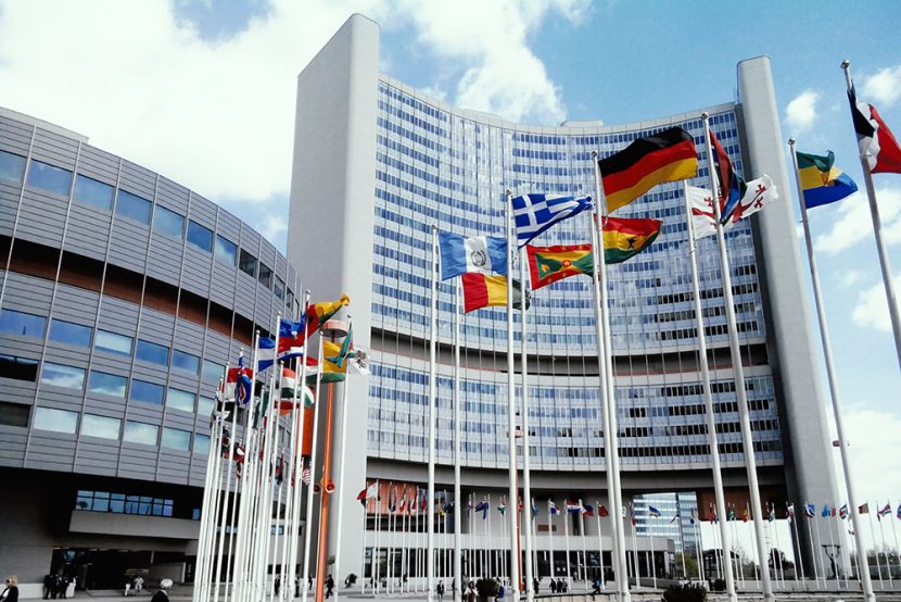 Various country flags fly outside a building.